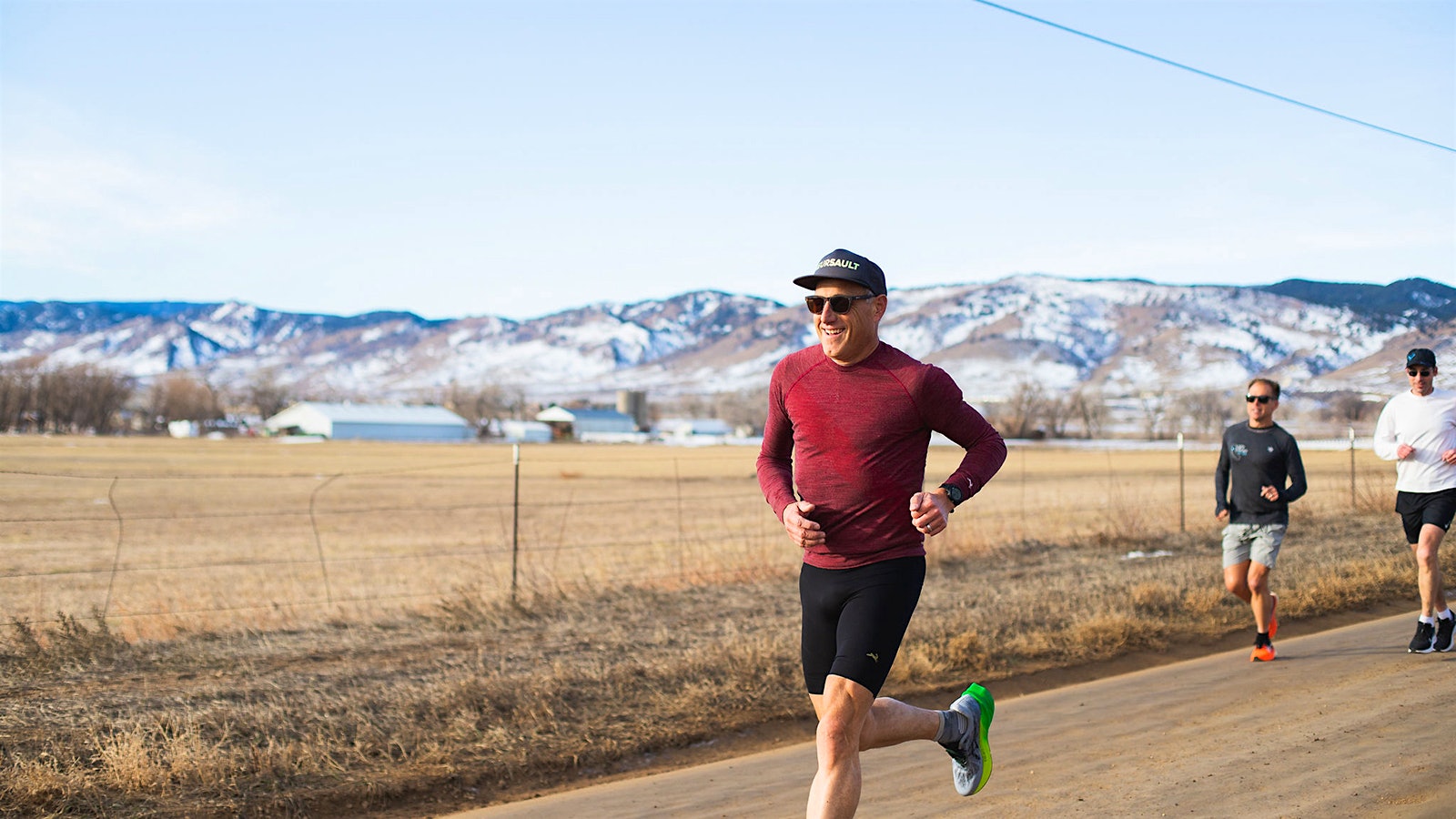 Bobby Stuckey running, with a snow-capped mountain visible in the background